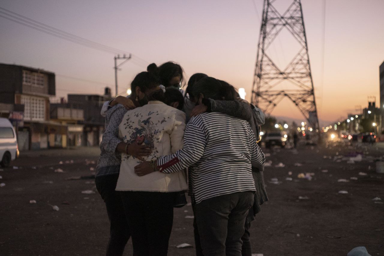 Ante la ausencia del Estado, la colectividad de las mujeres. Integrantes de la Asamblea Vecinal Nos Queremos Vivas Neza se abrazan durante una sesión de fotos después de una de sus jornadas “juntas comemos, juntas florecemos” en apoyo a las mujeres de su comunidad durante la pandemia de covid-19, 2020. Fotografía digital.